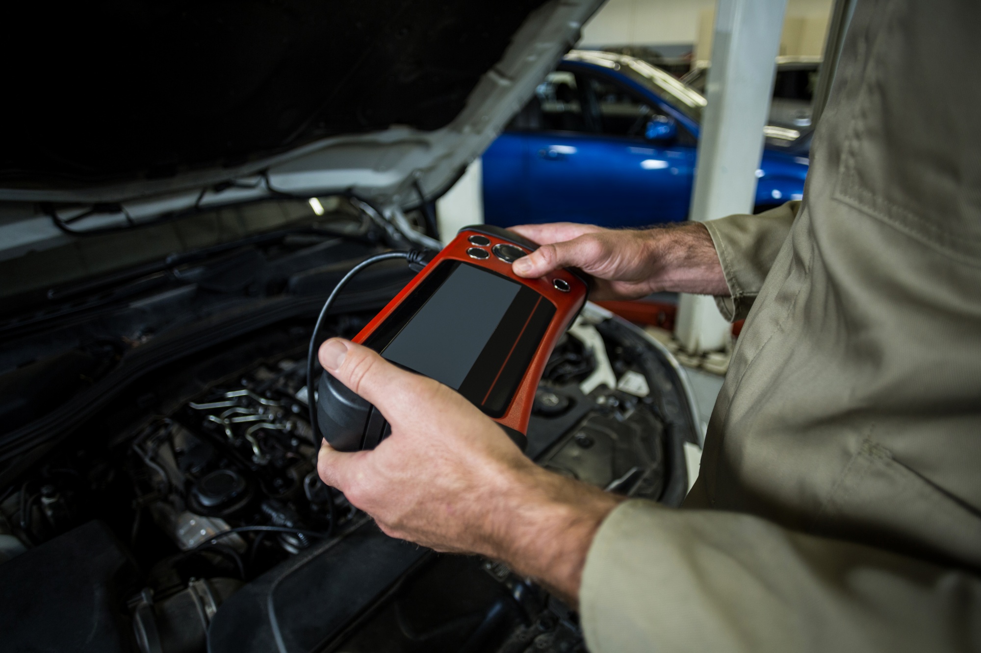 Technician performing Texas vehicle emissions inspection with OBD scanner